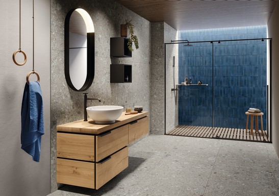Salle de bains moderne de luxe avec grès cérame effet pierre et carrelage mural dans des tons de bleu.