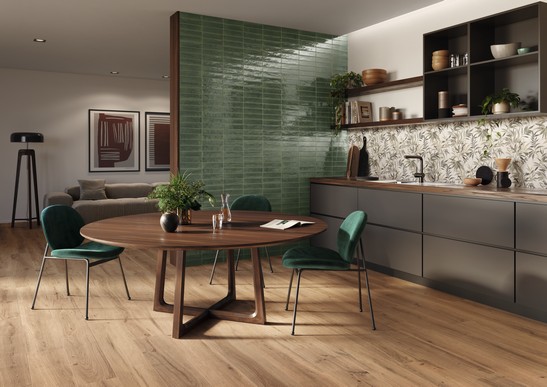 Cuisine linéaire ouverte dans des tons de beige et de vert avec avec grès cérame effet bois.