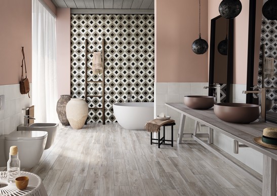 Salle de bains rustique avec baignoire, grès cérame imitation bois dans des tons de beige, de gris et de noir.