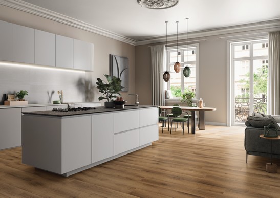 Cuisine de luxe linéaire ouverte avec sol effet bois marron et revêtement blanc
