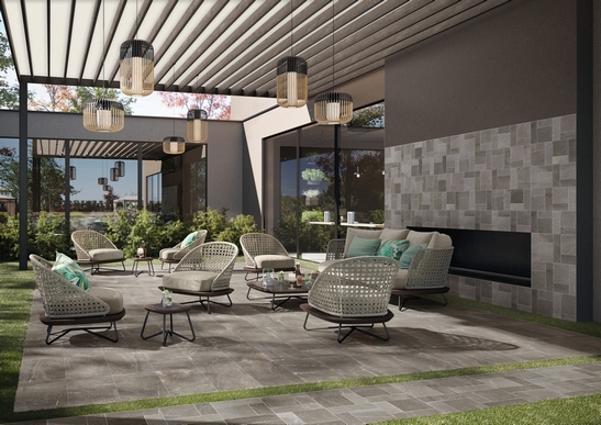 Terrasse bar-restaurant moderne, avec sol imitation pierre et tonalités grises.