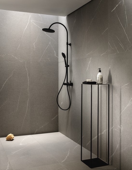 Bagno minimalista con doccia in gres effetto pietra sui toni del grigio