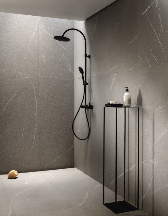 Salle de bains minimaliste avec douche en grès cérame effet pierre dans des tons de gris.