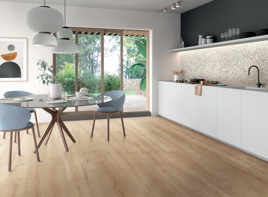 Cuisine moderne linéaire dans des tons beige et blanc avec sol effet bois.