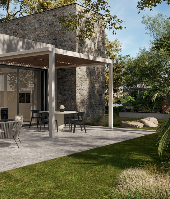 Patio moderno con giardino, pavimento in gres effetto pietra sui toni del grigio