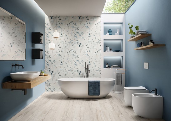 Bagno moderno dai toni blu con vasca, gres effetto carta da parati e pavimento effetto legno