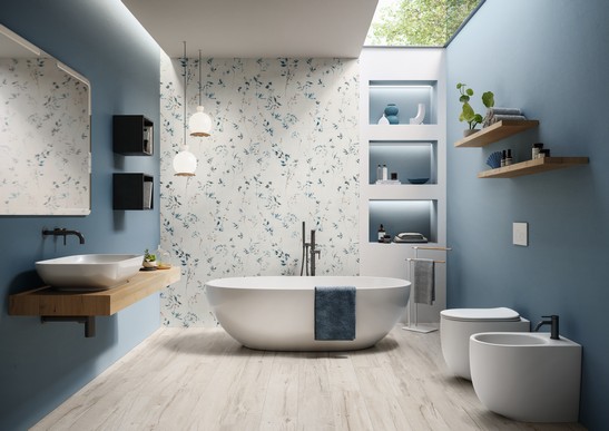 Salle de bains moderne dans des tons bleus avec baignoire, grès cérame effet papier peint et sol imitation bois.