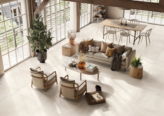 Séjour de luxe aux tons clairs avec sol en grès cérame effet béton.