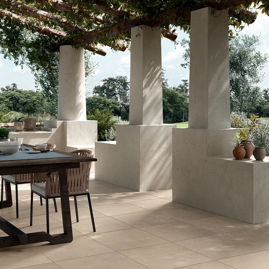 Terrasse couverte avec jardin, sol en grès cérame imitation pierre couleur sable.
