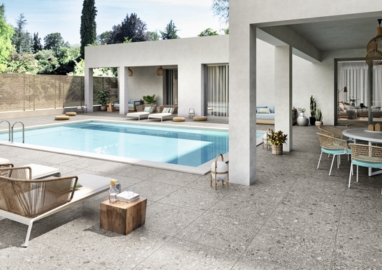 Terrasse moderne avec piscine, sol effet pierre dans des tons de gris.